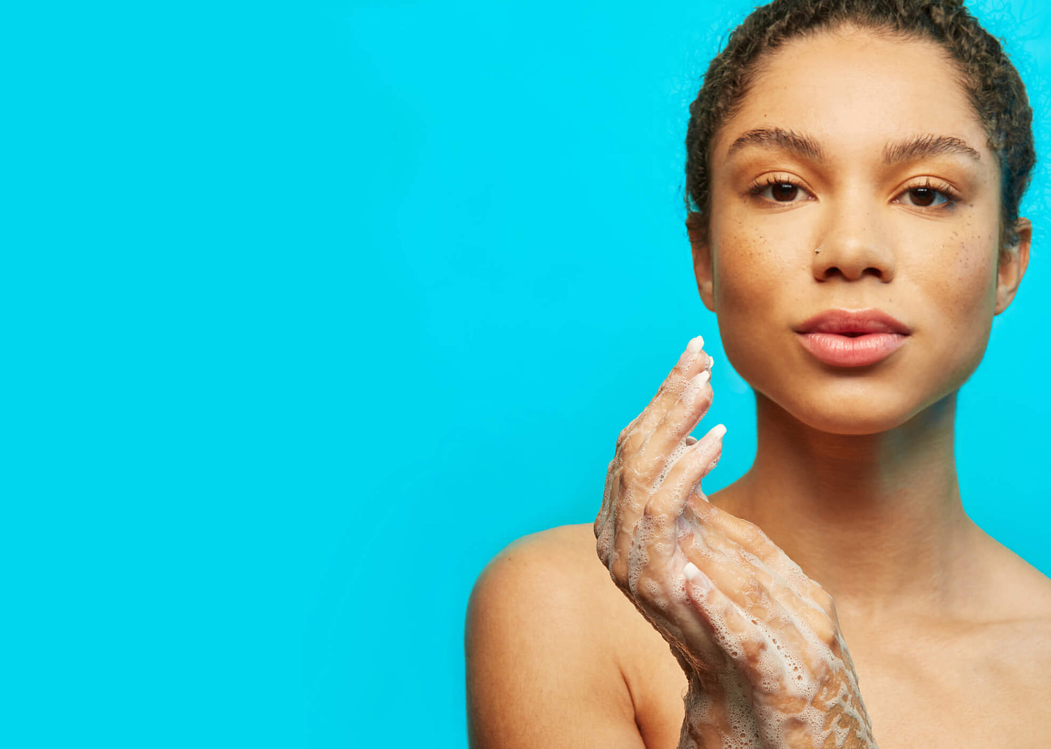 Woman washing her face on a blue background