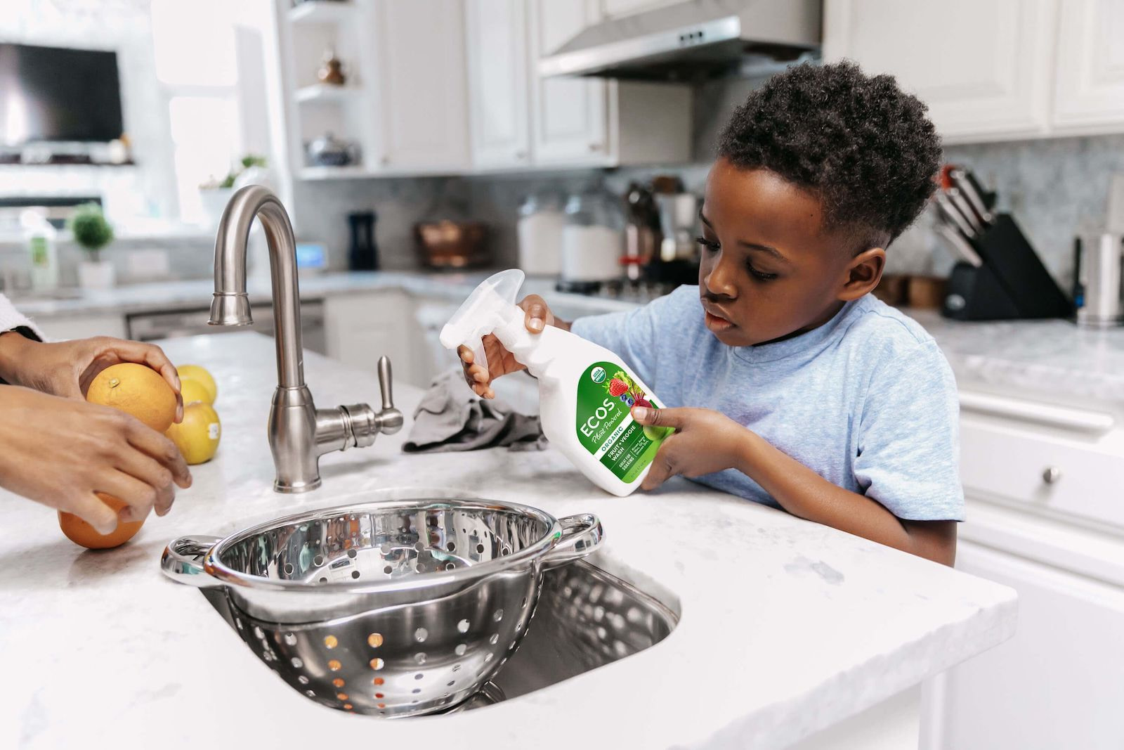 Kid Spraying Fruits with Fruit and Veggie Wash
