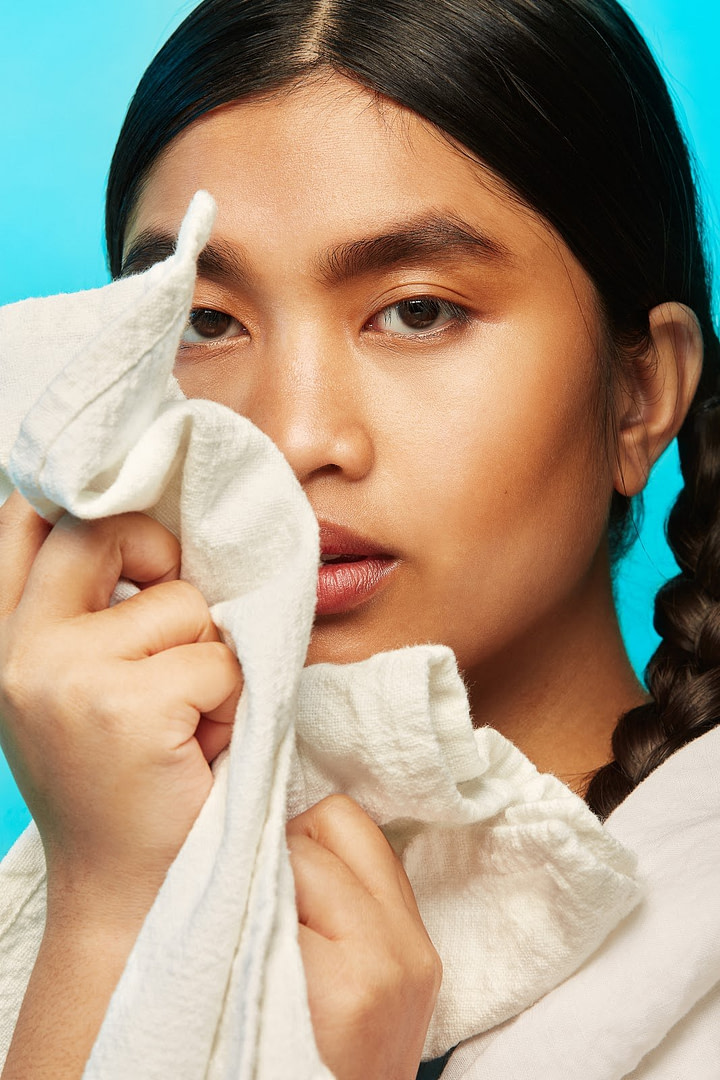 Woman Holding Clean Laundry To Face