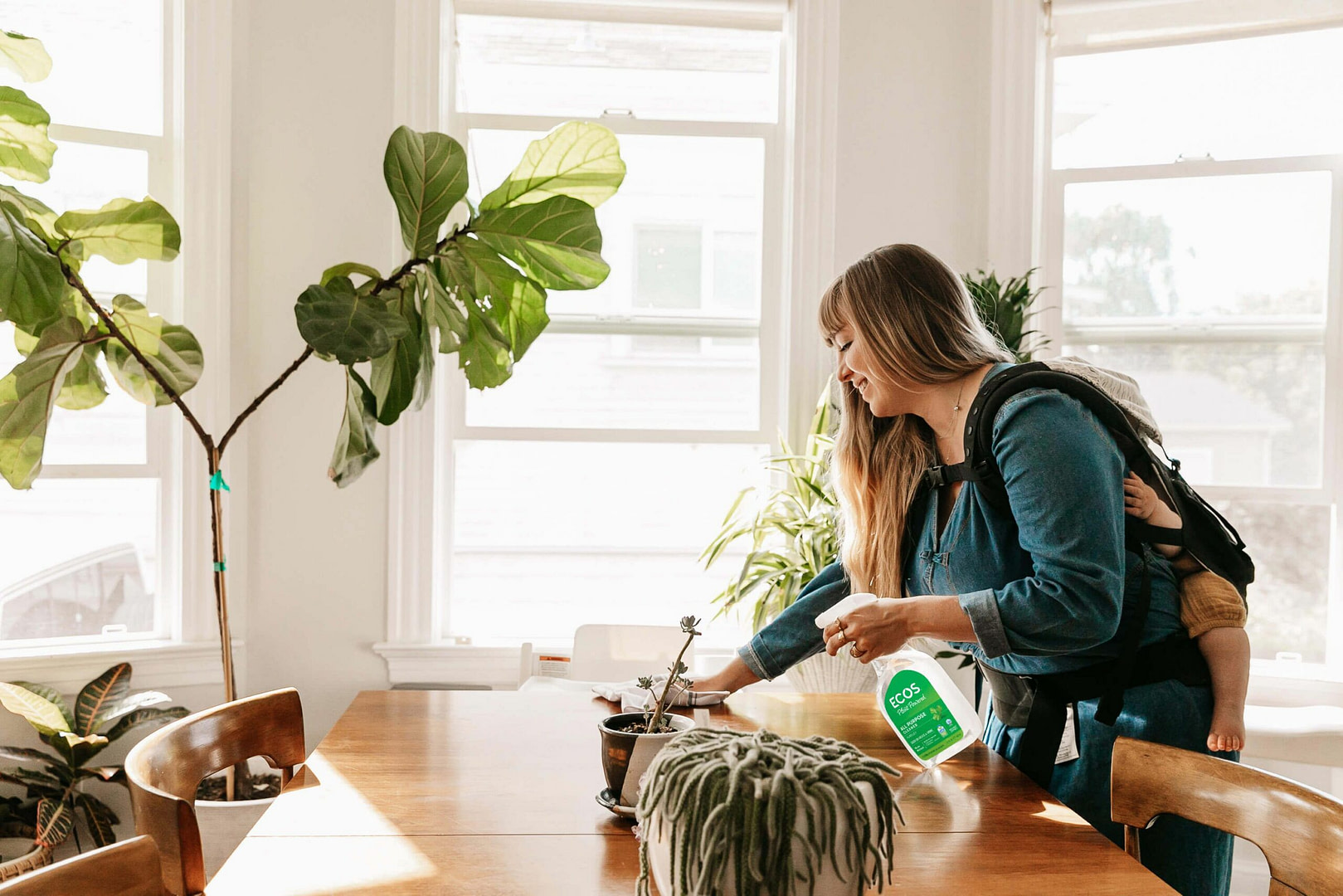 Mother Cleaning Table With Baby on Back