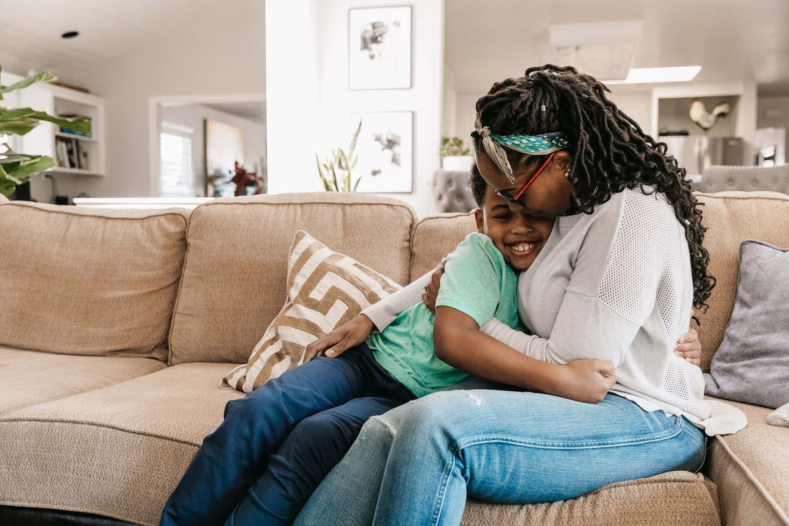 Mother Hugging Son on Couch At Home